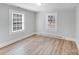 Bedroom featuring light wood floors, neutral walls, and plenty of natural light from two windows at 3138 Morson St, Charlotte, NC 28208