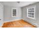 Bright bedroom featuring hardwood floors, neutral walls, and plenty of natural light from two windows at 3138 Morson St, Charlotte, NC 28208