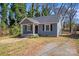 Charming blue house with dark shutters, a covered porch, a well-maintained lawn, and a gravel driveway at 3138 Morson St, Charlotte, NC 28208