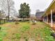 Spacious backyard featuring a hammock, mature trees, fire pit, black fence, and a covered porch area at 3300 Chancellor Ln, Monroe, NC 28110