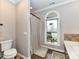 Bathroom featuring a tub with tile surround, a decorative window, and a toilet at 3300 Chancellor Ln, Monroe, NC 28110