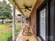 Inviting covered porch with rocking chairs, ceiling fans, and a view of the serene backyard with mature trees at 3300 Chancellor Ln, Monroe, NC 28110