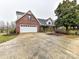 Exterior view of a two-story home with a brick facade, an attached garage, and a well-manicured front yard at 3300 Chancellor Ln, Monroe, NC 28110