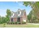 Charming two-story brick home with dormer windows and a well-manicured lawn and landscaping at 3300 Chancellor Ln, Monroe, NC 28110