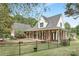 Lovely brick house with a welcoming front porch, rocking chairs, and a fenced yard at 3300 Chancellor Ln, Monroe, NC 28110