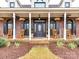 Inviting front porch with rocking chairs, black shutters, and decorative hanging baskets at 3300 Chancellor Ln, Monroe, NC 28110