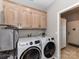 Spacious laundry room with front load washer/dryer and ample cabinet storage above at 3300 Chancellor Ln, Monroe, NC 28110