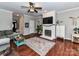 Inviting living room featuring a white painted brick fireplace and dark wood floors at 3300 Chancellor Ln, Monroe, NC 28110