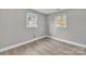 Well-lit bedroom featuring wood-look flooring and two windows at 3301 10Th Ne Ave, Conover, NC 28613