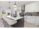 Eat-in kitchen featuring an island with seating, white cabinets, and modern pendant lighting at 3308 Polk And White Rd, Charlotte, NC 28269