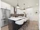 Modern kitchen with stainless steel appliances, a large island with seating, and sleek white cabinetry at 3308 Polk And White Rd, Charlotte, NC 28269