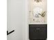 Stylish powder room with black vanity, marble countertop, round mirror, and modern lighting at 3312 Polk And White Rd, Charlotte, NC 28269