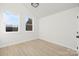 Bright bedroom featuring light wood floors, neutral paint, and double windows with a view at 3312 Polk And White Rd, Charlotte, NC 28269