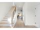 Bright entryway with hardwood floors, an open staircase with black rails, and a view into the living area at 3312 Polk And White Rd, Charlotte, NC 28269