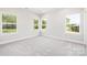 Bright bedroom with carpet flooring and natural light from three windows at 338 Hudson St, Shelby, NC 28150