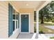 Inviting front entrance with a blue front door, white columns, and manicured landscaping at 338 Hudson St, Shelby, NC 28150