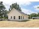 View of a home's tan siding, white trim, and neatly maintained grassy yard and landscaping at 338 Hudson St, Shelby, NC 28150