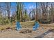 Inviting backyard firepit area with blue Adirondack chairs amidst a natural setting at 3723 Annlin Ave, Charlotte, NC 28209