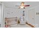 Bedroom featuring a crib, a comfortable chair, a window, and pink polka dot wallpaper at 3723 Annlin Ave, Charlotte, NC 28209