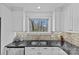 Well-lit kitchen featuring white cabinets, stainless steel appliances, and a window with a scenic outdoor view at 3723 Annlin Ave, Charlotte, NC 28209