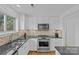 Modern kitchen sink with stainless steel appliances, mosaic tile backsplash, and custom cabinetry for a sleek cooking space at 3723 Annlin Ave, Charlotte, NC 28209