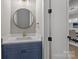 Stylish powder room with a navy blue vanity, quartz countertop, and round mirror at 3945 Ostler Ct, Lancaster, SC 29720