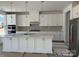 Bright white kitchen with stainless steel appliances, large island, and stylish backsplash at 4122 Eastover Glen Rd # 0316, Charlotte, NC 28269