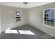 Well-lit bedroom featuring two large windows and neutral wall tones at 4683 Falcon Chase Sw Dr, Concord, NC 28027