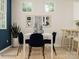 Modern dining room with white table, blue chairs, and a view of the kitchen at 5725 Olive Beach Rd, Kannapolis, NC 28081