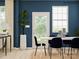 Modern dining room with white table, blue chairs, and a blue accent wall at 5725 Olive Beach Rd, Kannapolis, NC 28081