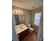 Neutral-toned powder room with a window for natural light and classic fixtures at 5956 Prescott Ct, Charlotte, NC 28269