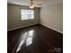 Bedroom features wood-look flooring, neutral paint, and a window for natural light at 5956 Prescott Ct, Charlotte, NC 28269