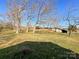 Spacious backyard featuring large mature trees, lush grass, and a detached shed at 6523 Prospect Rd, Monroe, NC 28112