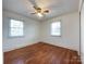 Cozy bedroom with hardwood floors, ceiling fan, and two windows offering natural light at 6523 Prospect Rd, Monroe, NC 28112