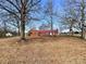 Charming brick home with a bright red roof and a spacious yard surrounded by mature trees on a sunny day at 6523 Prospect Rd, Monroe, NC 28112