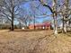 The home exterior sits in the yard framed by the branches of mature trees at 6523 Prospect Rd, Monroe, NC 28112