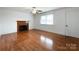 Living room showcasing hardwood floors, fireplace, and natural light from a large window at 6523 Prospect Rd, Monroe, NC 28112