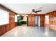 Open concept view of living room with wood paneling leading into the kitchen with green cabinets at 6523 Prospect Rd, Monroe, NC 28112