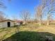 View of outbuildings in the backyard, including a storage shed and a red roofed open air shed at 6523 Prospect Rd, Monroe, NC 28112