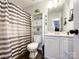 Clean bathroom with a striped shower curtain and white vanity at 7562 Silver Arrow Dr, Charlotte, NC 28273