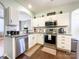 Modern kitchen with white cabinets, granite counters, and stainless steel appliances at 7562 Silver Arrow Dr, Charlotte, NC 28273