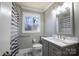 Updated bathroom with a gray vanity and striped shower curtain at 7716 Elwood Dr, Charlotte, NC 28227