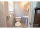 Small bathroom with pedestal sink and toilet at 7716 Elwood Dr, Charlotte, NC 28227