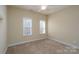 Bright bedroom with two windows and neutral carpeting at 8809 Landsdowne Ave, Harrisburg, NC 28075