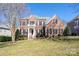 Two-story brick home with a manicured lawn and shutters at 8809 Landsdowne Ave, Harrisburg, NC 28075