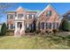 Brick two-story house with black shutters, white columns, and a manicured lawn at 8809 Landsdowne Ave, Harrisburg, NC 28075