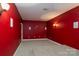 Home theater room with red walls and carpeted floor at 8809 Landsdowne Ave, Harrisburg, NC 28075