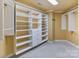 Spacious walk-in closet with custom white shelving and drawers for optimal storage solutions at 1020 James Madison Dr, Weddington, NC 28104