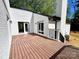 Exterior white painted brick patio features a wooden deck, black railing, and sliding glass door access to the home at 108 Vance Allen Ave, Rockwell, NC 28138