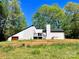 Back exterior view of home with deck, chimney, and garage in a natural setting at 108 Vance Allen Ave, Rockwell, NC 28138